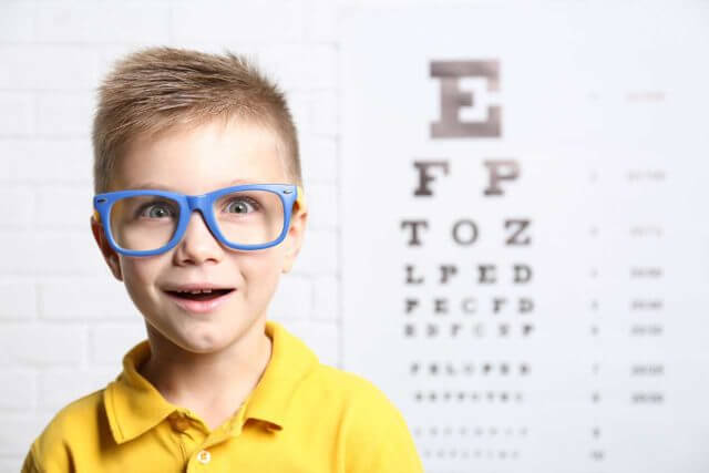 little boy with eyeglasses in his school eye exam