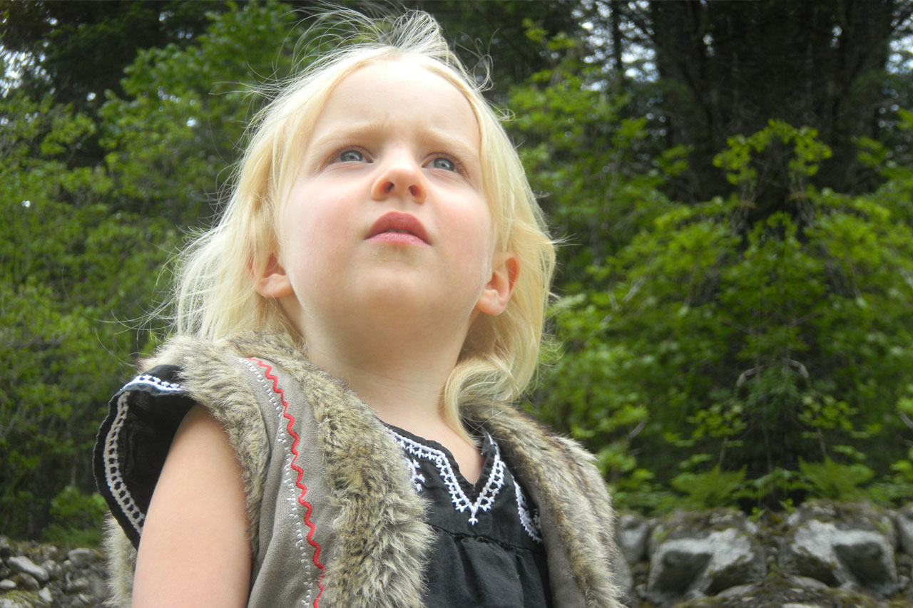 blonde child with blue eyes, looking to sky