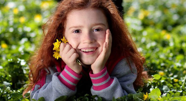 Girl Smiling Grass Flower blog image.jpg