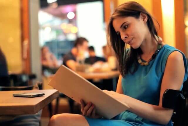 young woman with convergence insufficiency reading restaurant menu