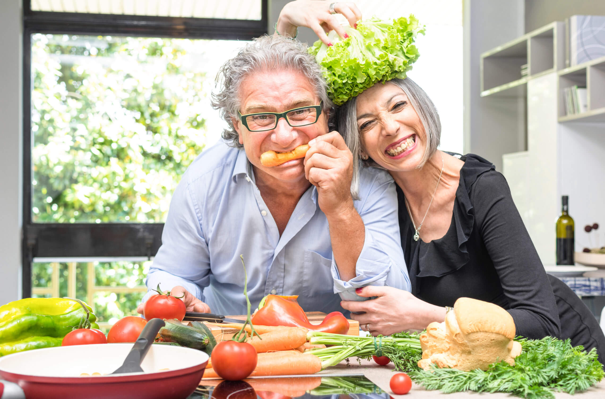 Senior couple having fun in kitchen with healthy food   Retired poeple cooking together vegetarian gourmet plate at home