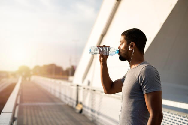 attractive-athlete-holding-bottle-water-drinking-before-training_342744-642