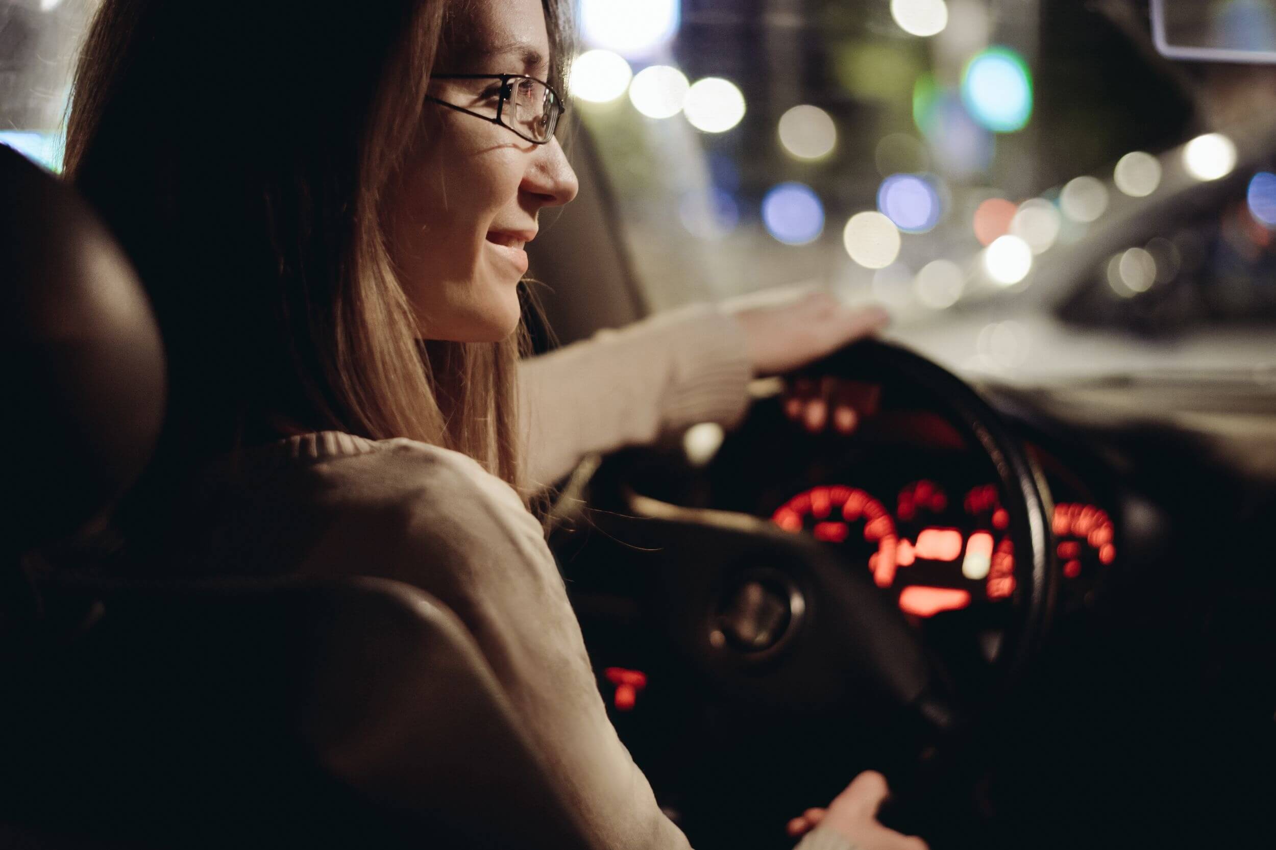 Woman driving car by night in the city
