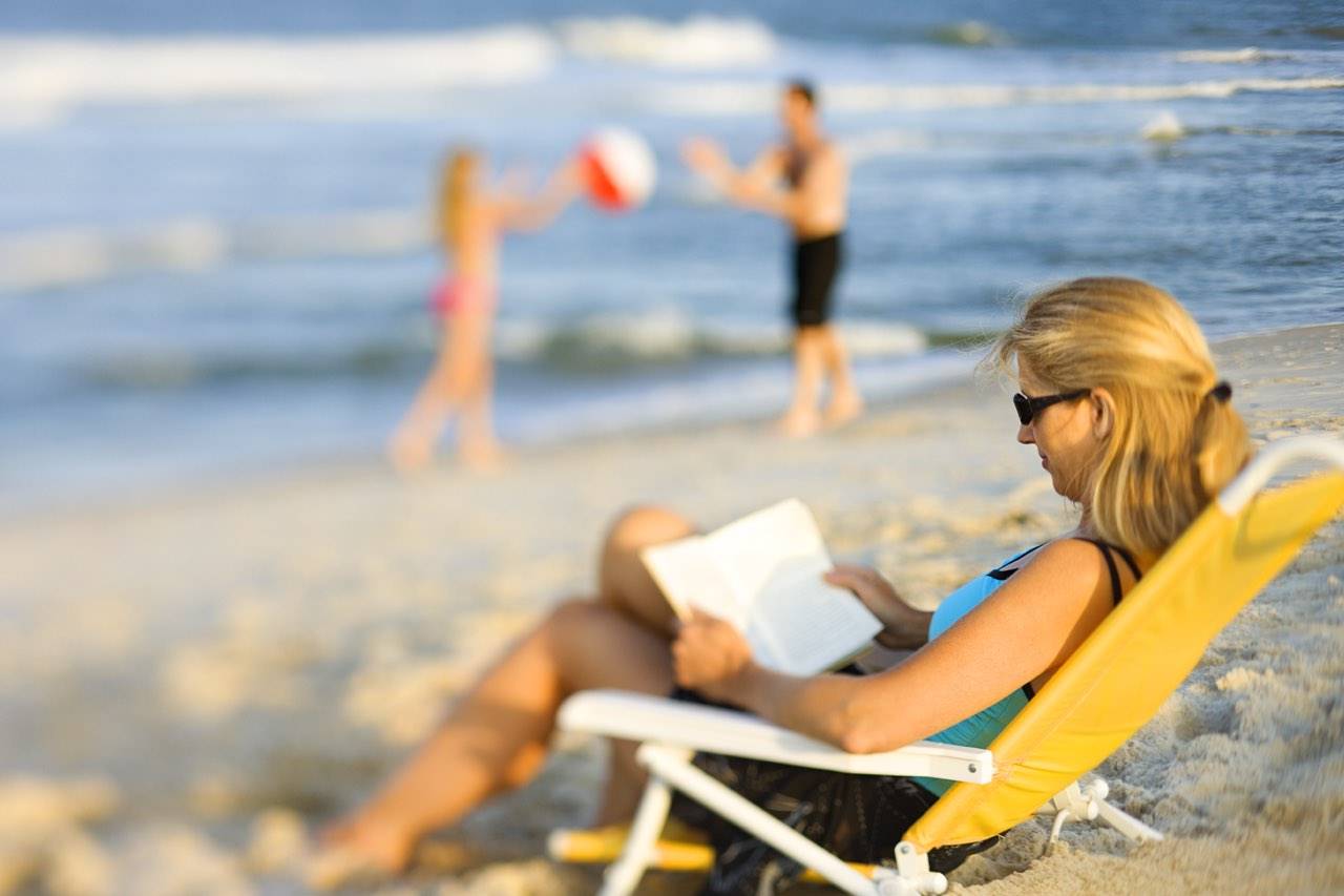 beach woman reading blurred 1280×853
