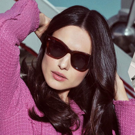 woman wearing oliver peoples sunglasses pink jacket