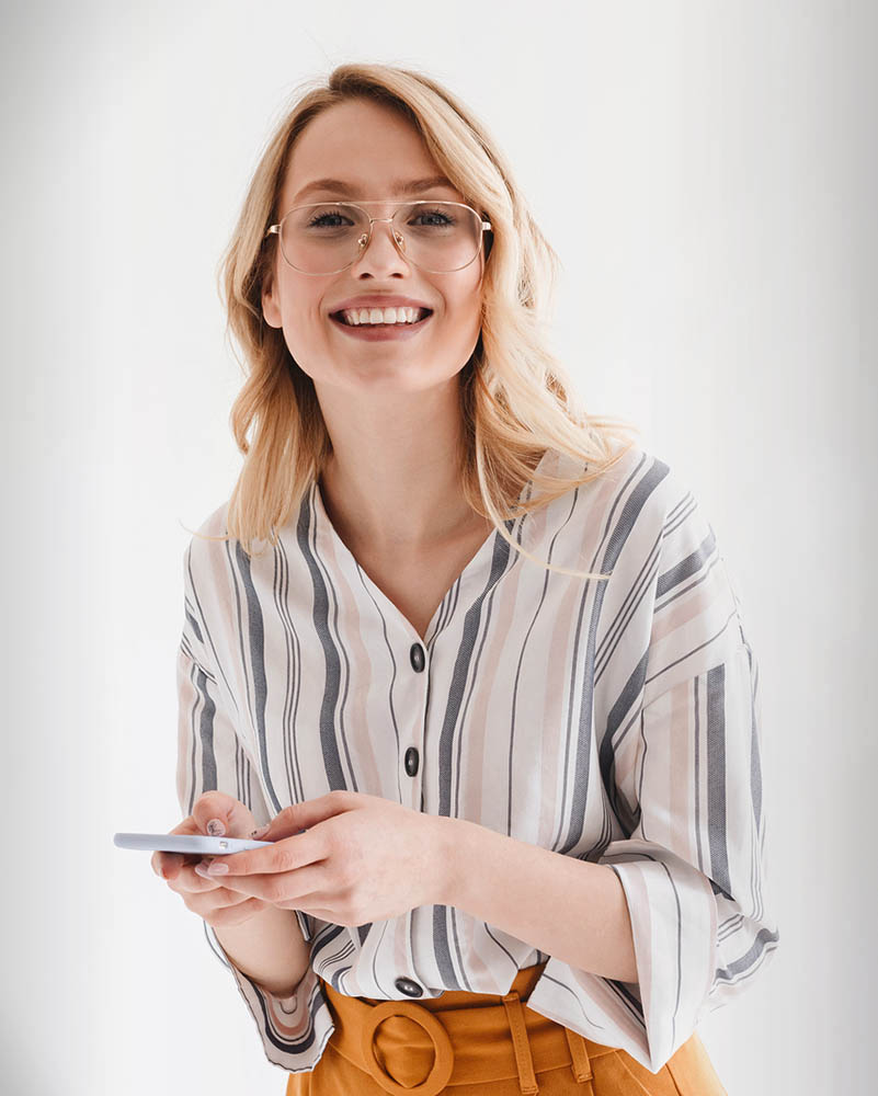 Photo of optimistic beautiful woman wearing glasses smiling at c
