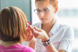 Optometrist-checking-eyes-of-woman