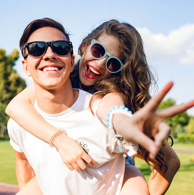 man and woman smiling with sunglasees