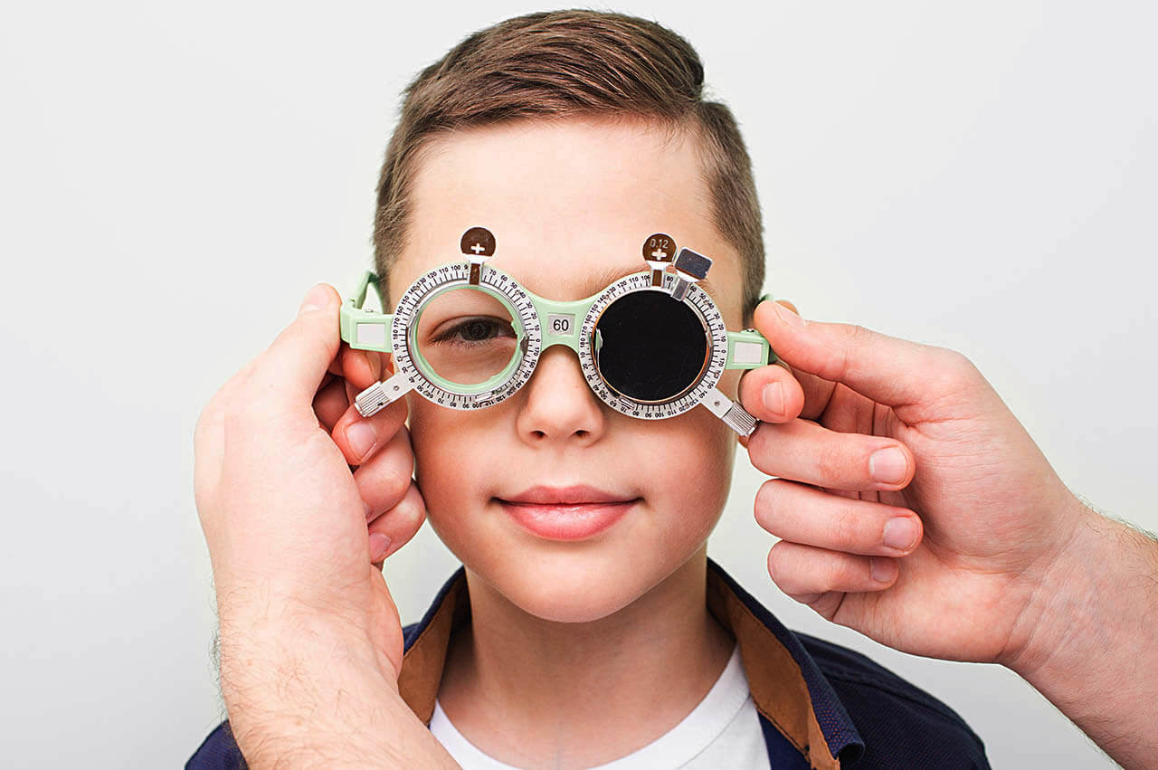 Optometrist Putting On The Boy Special Glasses To Restore Visual