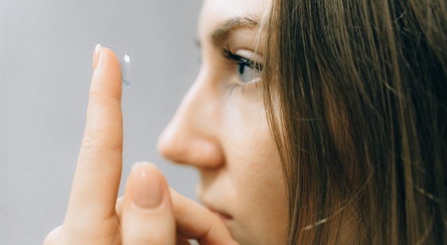 girl putting on a contact lens 640x350