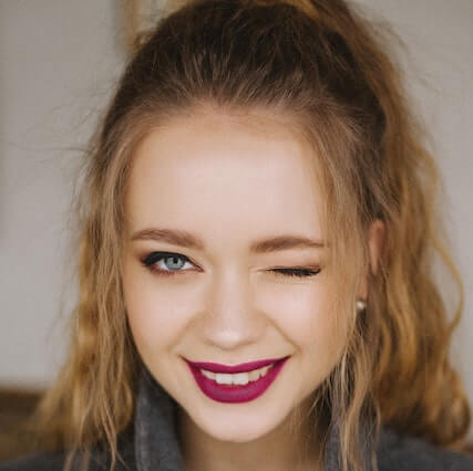 girl smiling wearing contact lenses winking
