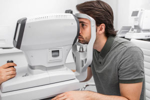 Handsome Man Checking Eyesight In A Clinic Using Diagnostic Opht