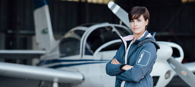 Woman standing in front of her airplane Adobe