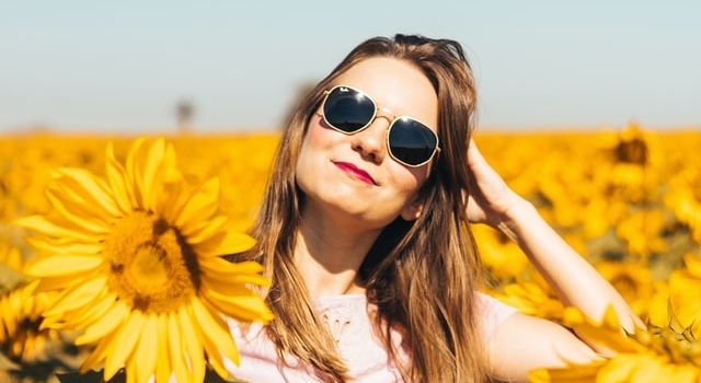 woman wearing sunglasses in field of sunflowers 640.jpg
