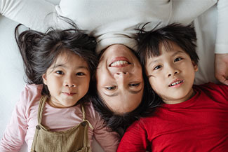 mom and two kids lying in bed