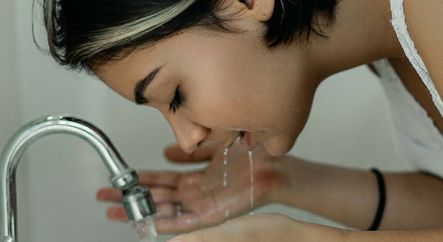 woman washing her face with water 2087954