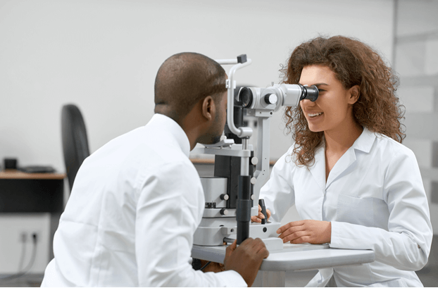 Man undergoing eye exam by his optometrist at eye doctor clinic