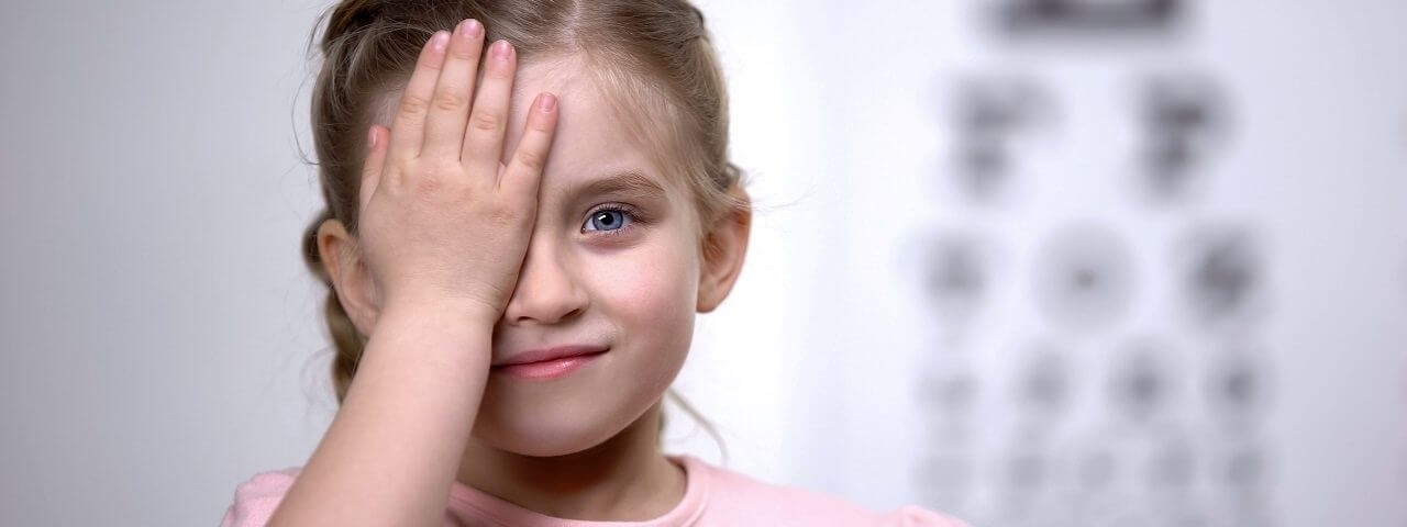 child hand over eye eyecart behind