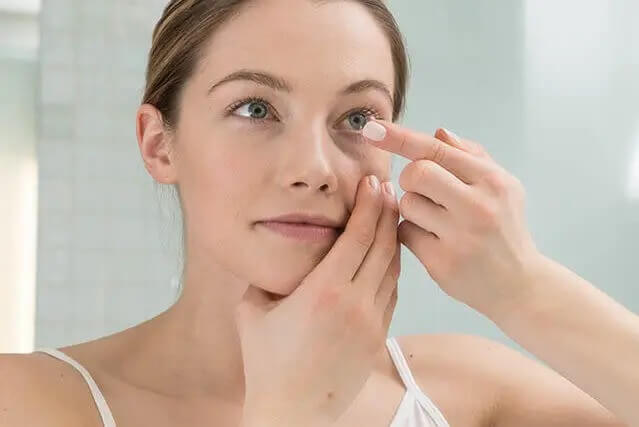 woman inserting contact lenses