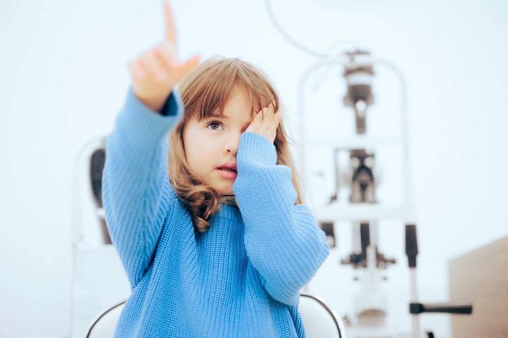 Toddler child pointing to a vision chart during eye check