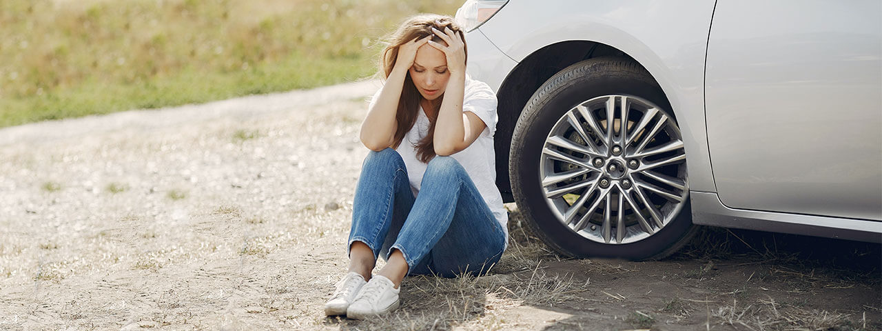 Woman sitting in front of a Car Accident