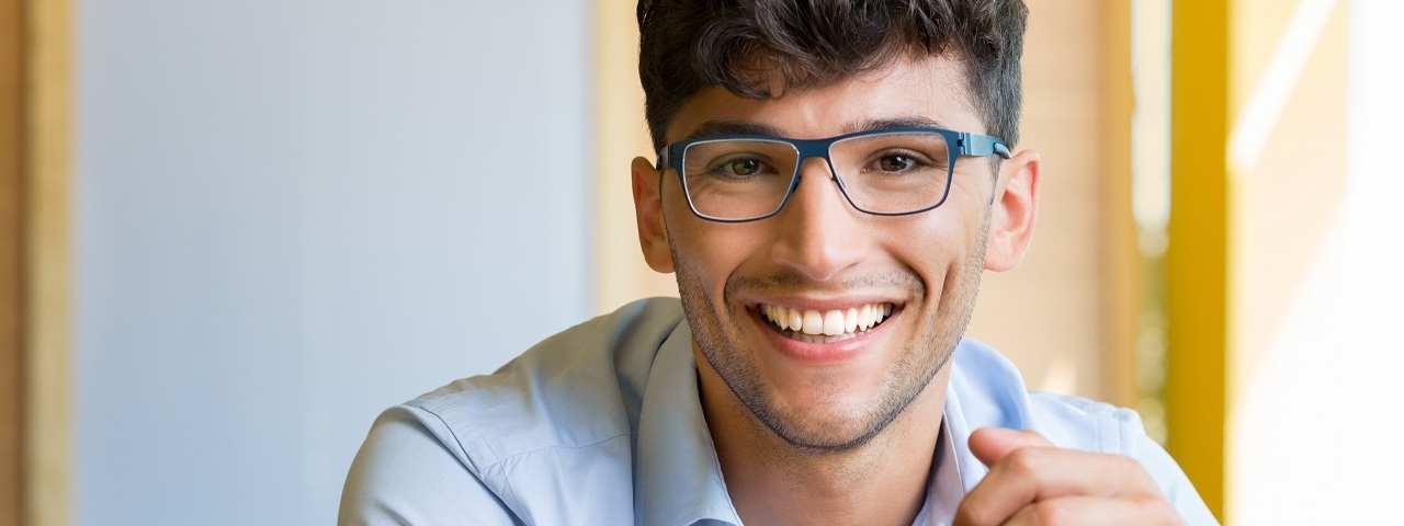 young man wearing eyeglasses at desk