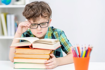 boy reading book with eyeglasses myopia