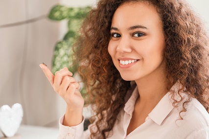 young woman curly hair contact lens on finger