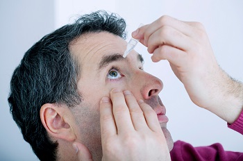 man putting in eye drops