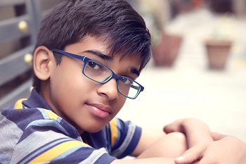 young boy modeling blue eyeglasses