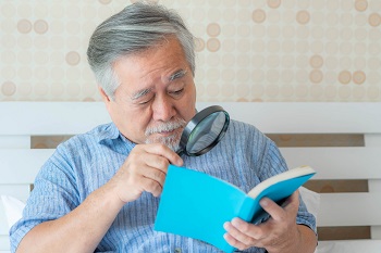 senior man reading with magnifier