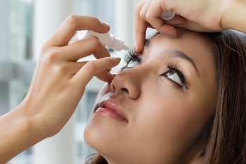 woman putting in eyedrops
