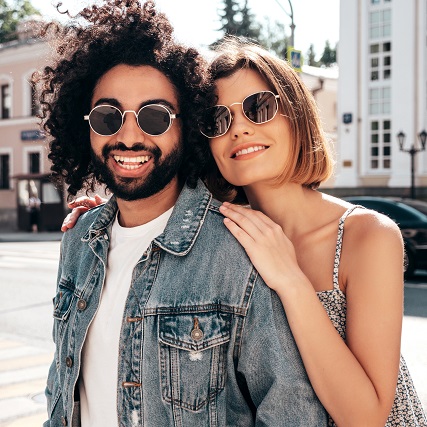 happy-couple-sidewalk-modeling-sunglasses