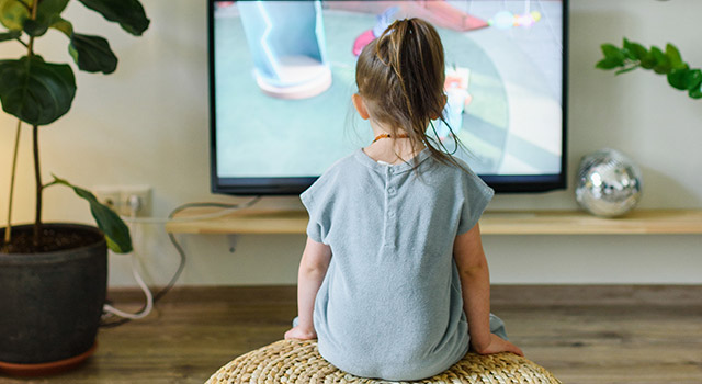Girl sitting in front of tv screen