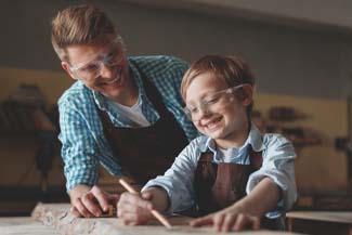 Smiling father and son with glasses at work