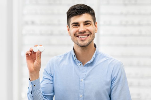 Happy guy holding contact lens case