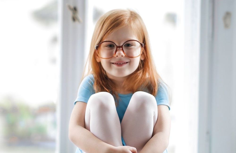 child girl redhead smiling glasses blue ballet dress
