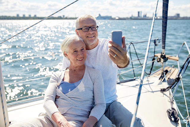 senior couple taking selfie while sailing