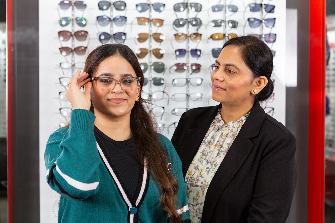 Patient and optician fitting glasses