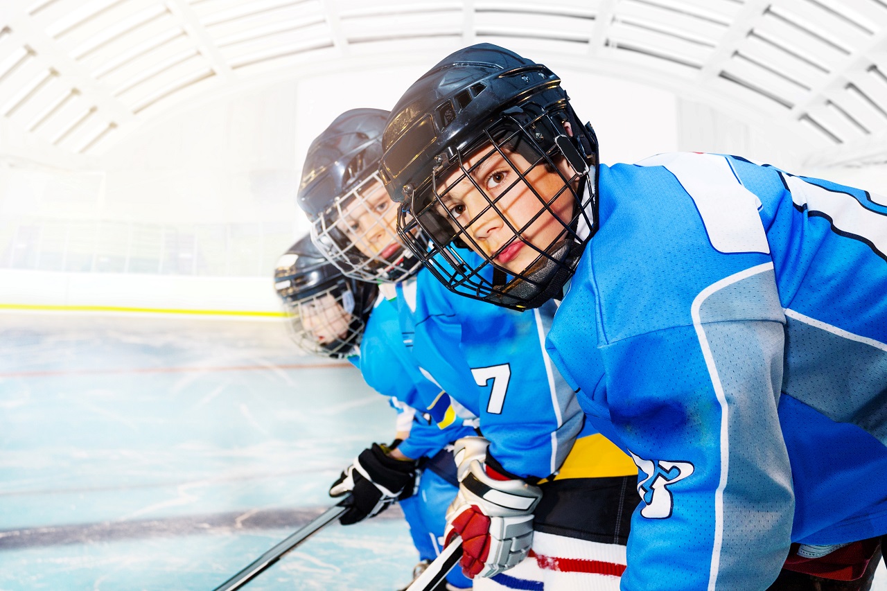 young hockey players posing by goal