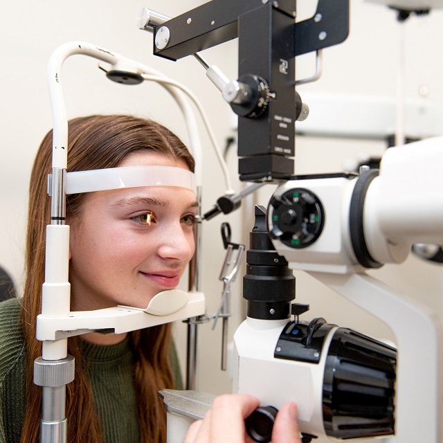 optometrist and patient behind slit lamp