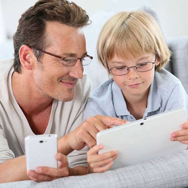 Father and son playing on tablet