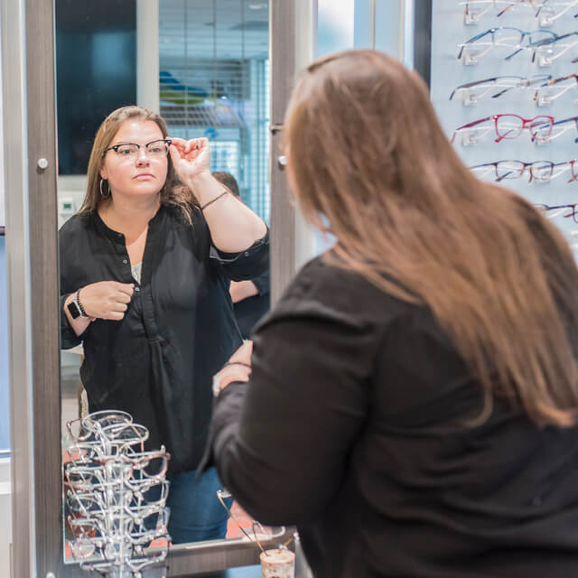 young woman trying on a new pair of eyeglasses