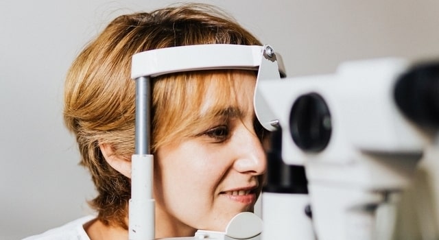 middle aged woman at an eye exam 640x350