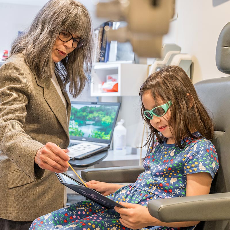 Eye Doctor Fitting Glasses On Patient