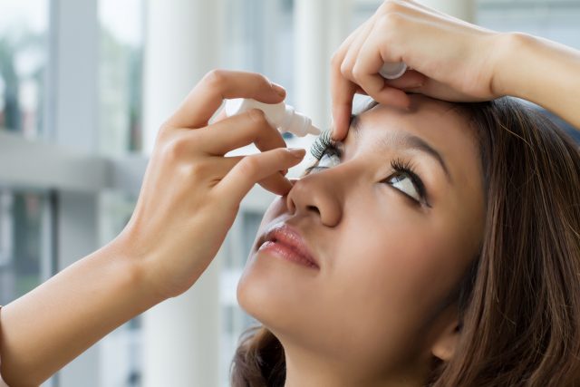 woman using eye drops
