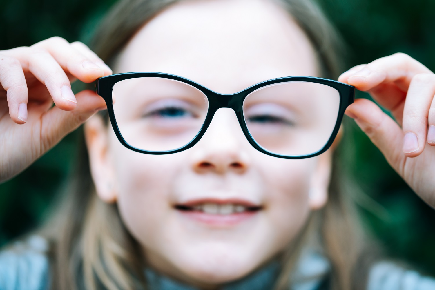 Closeup portrait of little girl with myopia correction glasses