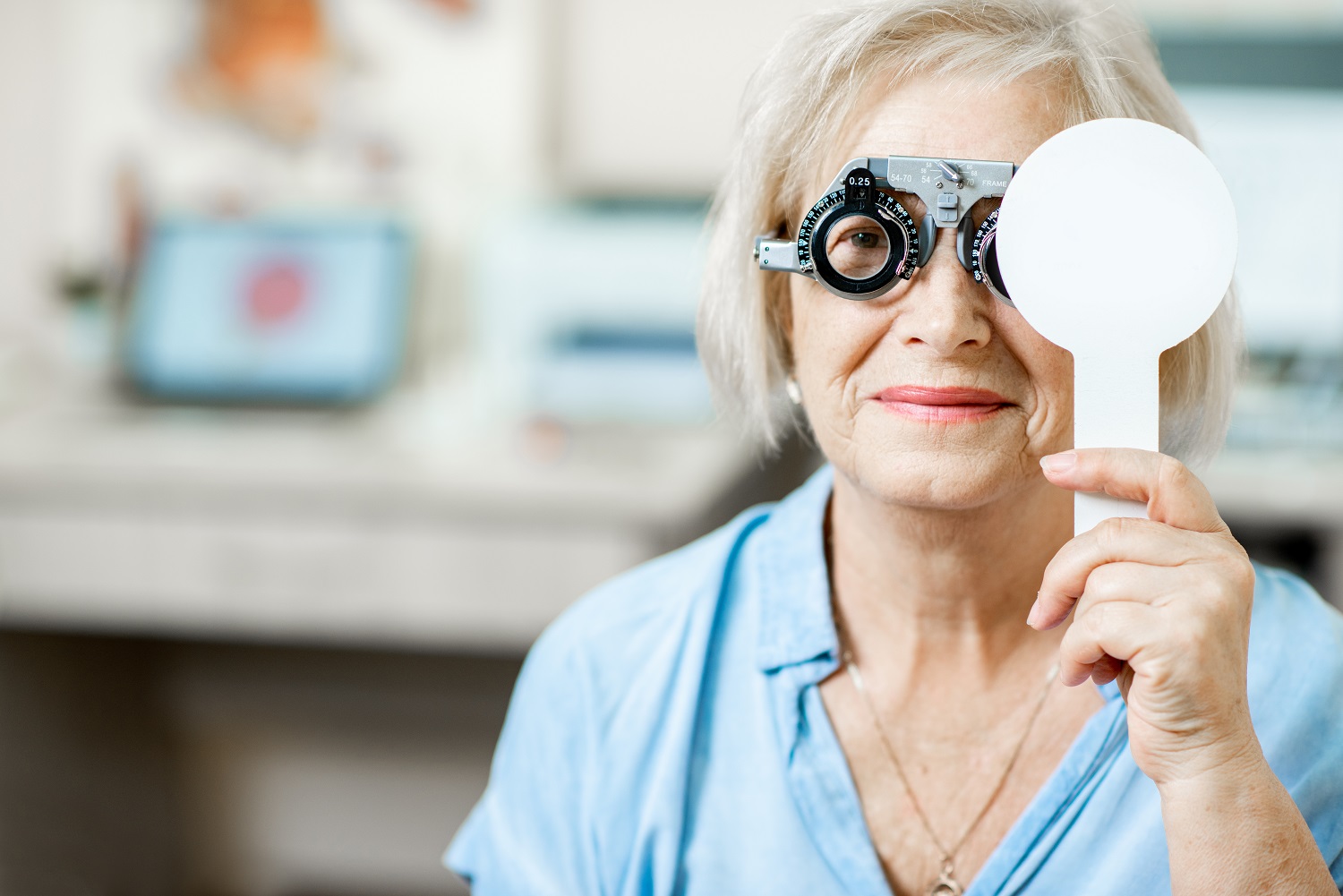 Senior woman checking vision with eye test glasses