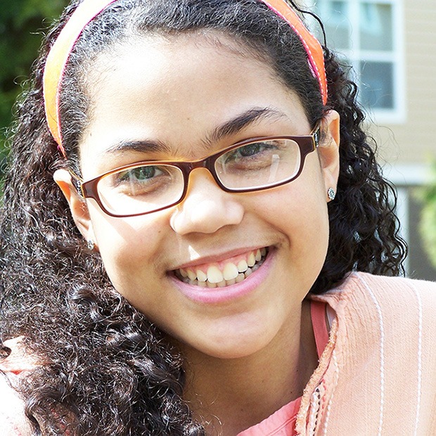 Young girl smiling with glasses and headband