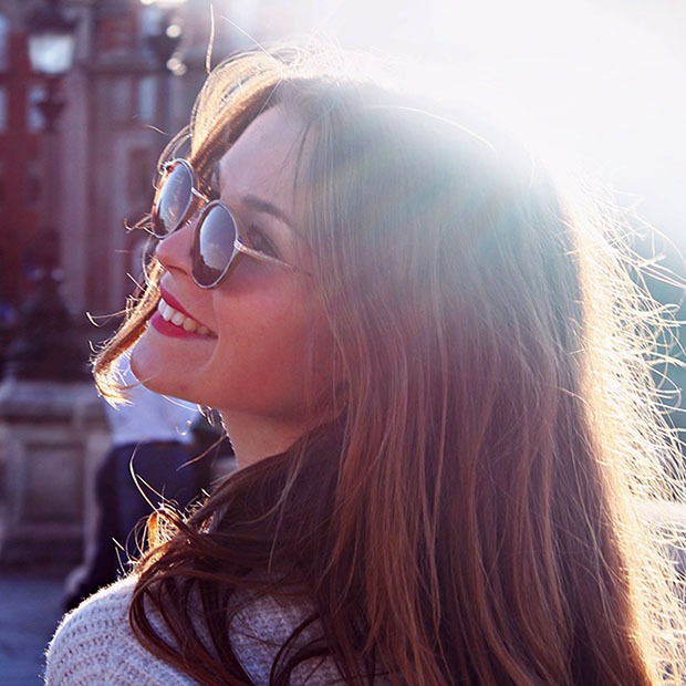 Young girl with light against her hair, wearing sunglasses